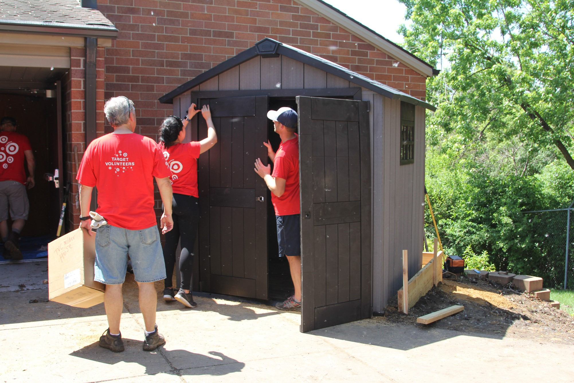 Volunteers work on a new shed outside the Wilder Center for Social Healing