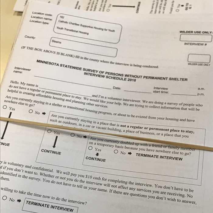 A stack of blank Minnesota Homeless Study survey instruments bound by a rubber band.