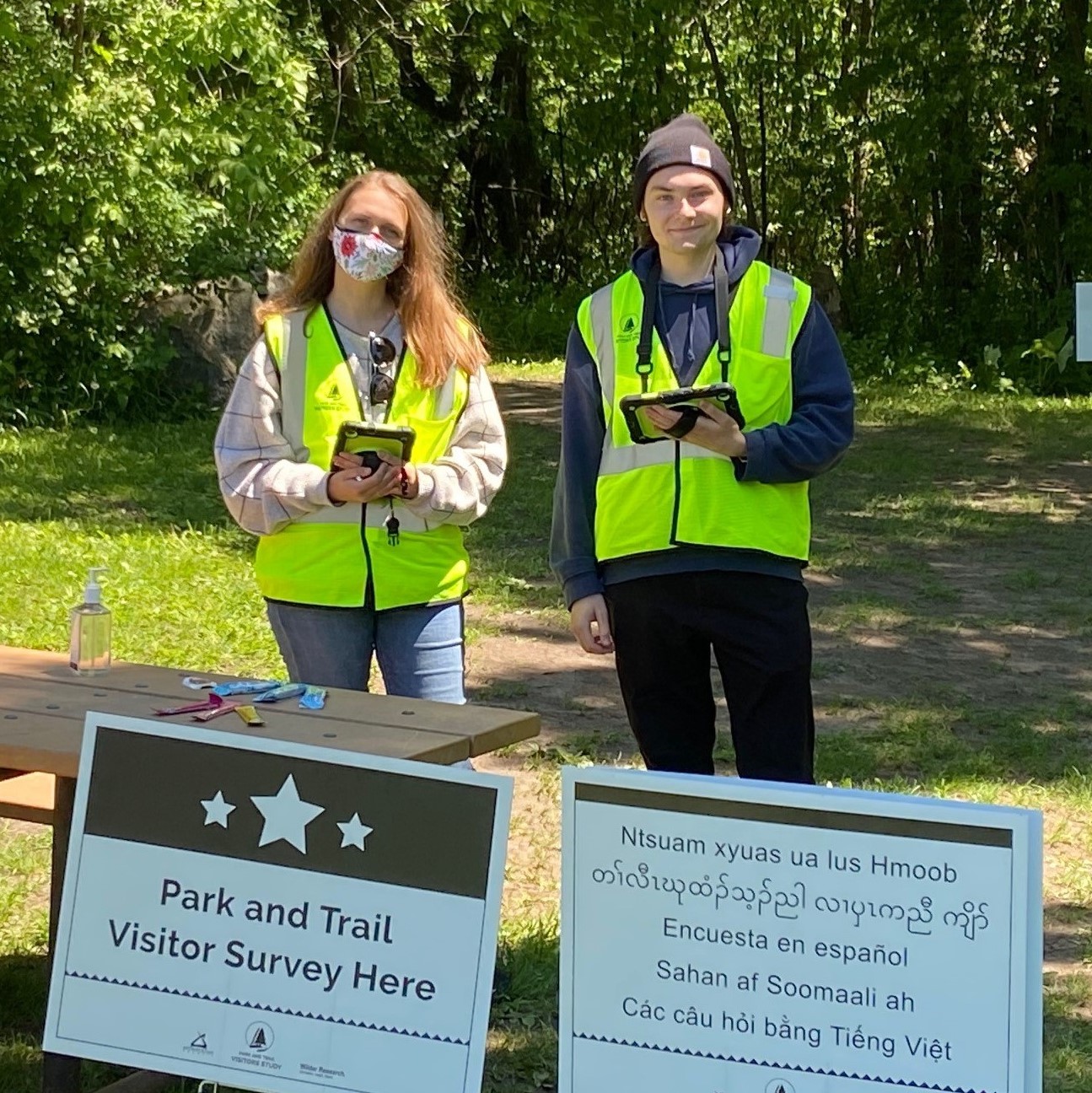 Two people standing outside holding note pads