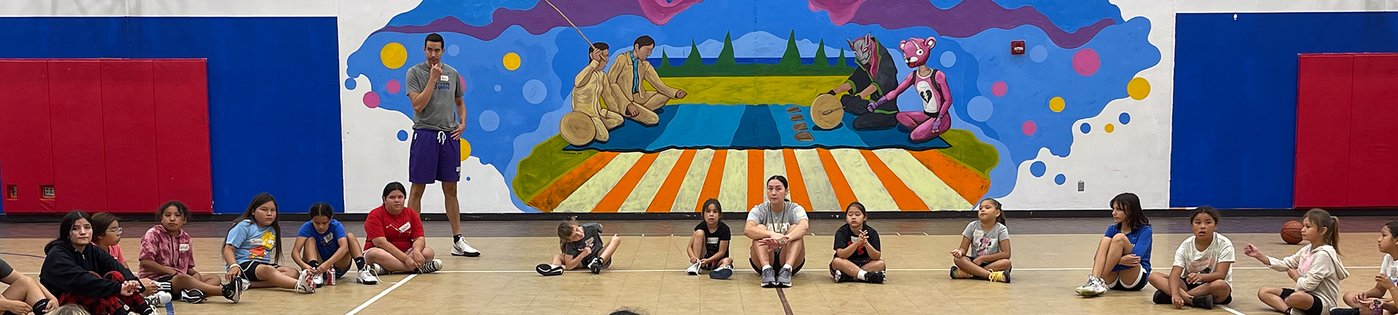 Children sitting in a line in a gymnasium on the Red Lake Nation