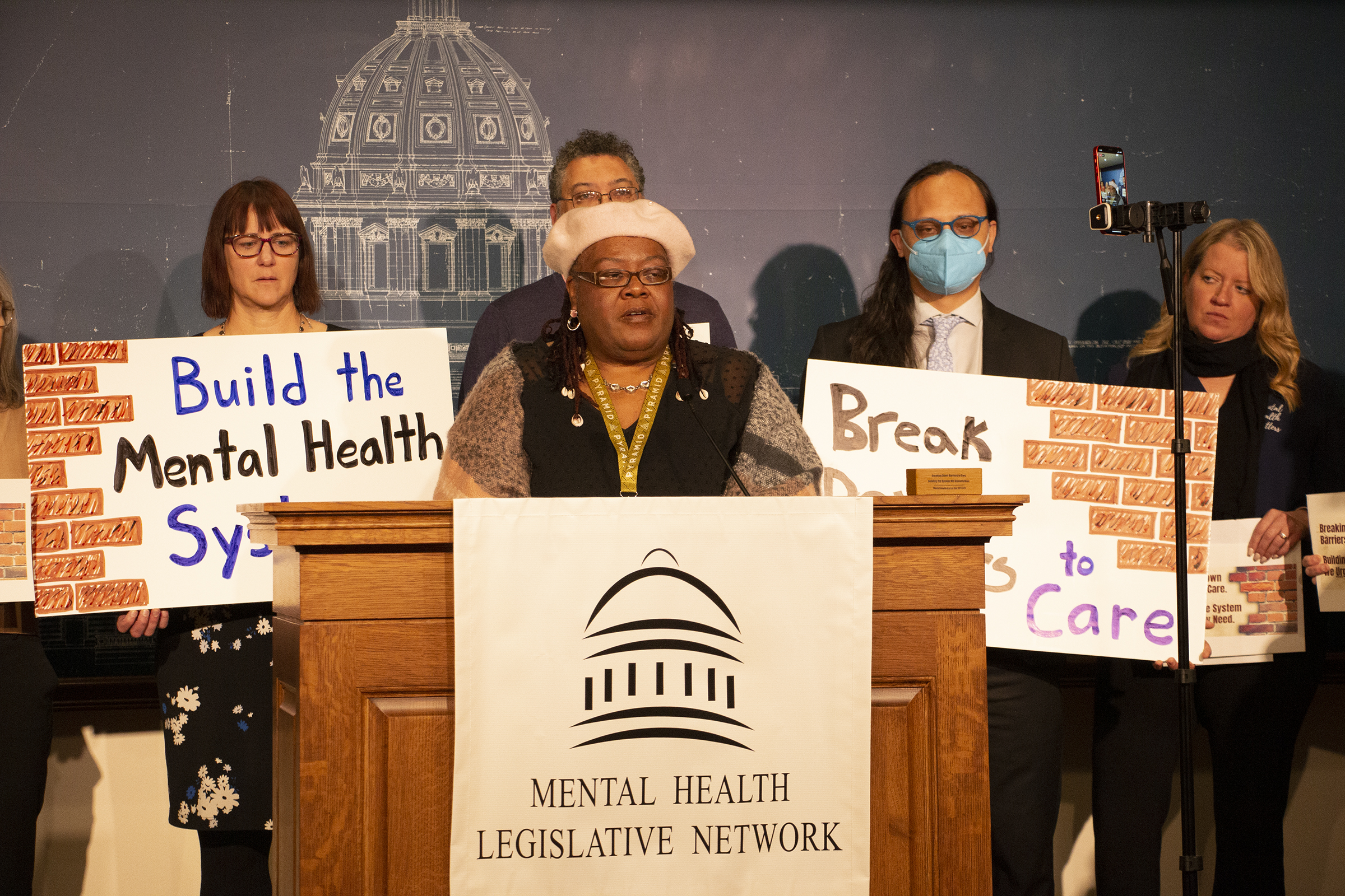 Woman standing behind podium with four people behind her