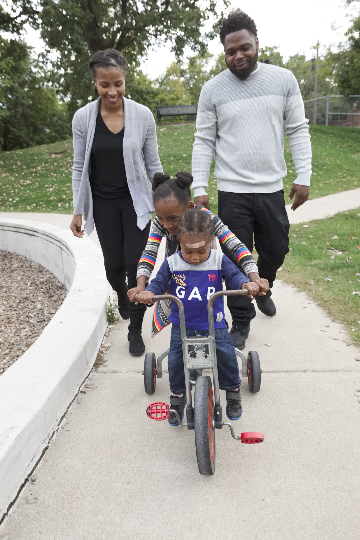 african american family in saint paul minnesota, african american mother and father with daughter and son on bicycle, wilder child development center family, minnesota community childcare, preschool family
