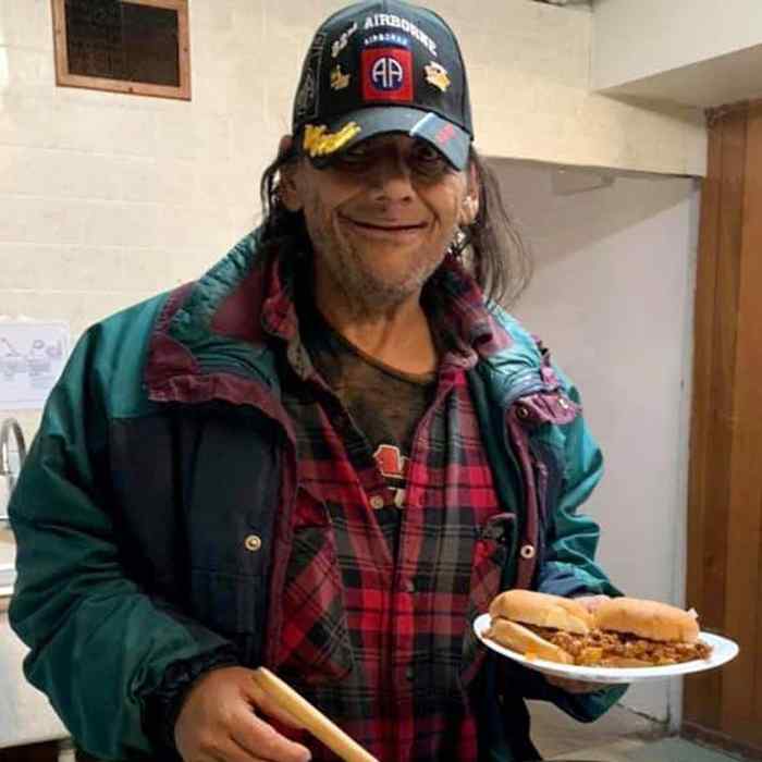 A man holds a plate of food.