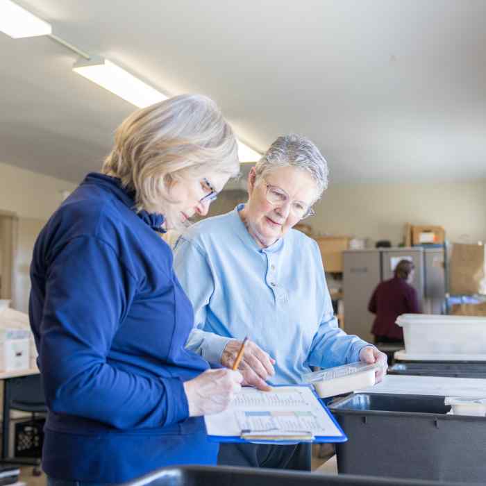 Two Meals on Wheels volunteers review the meal list for clients.