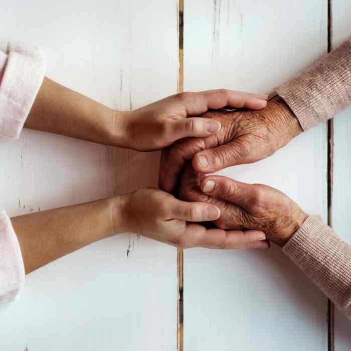 Two pairs of hands holding across a table.