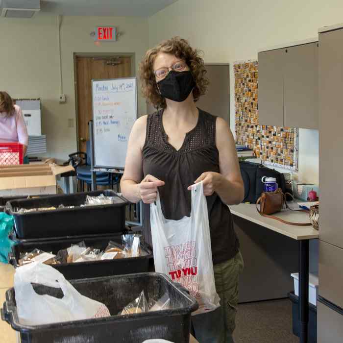 Meals on Wheels volunteer with plastic bag of food packed for customer