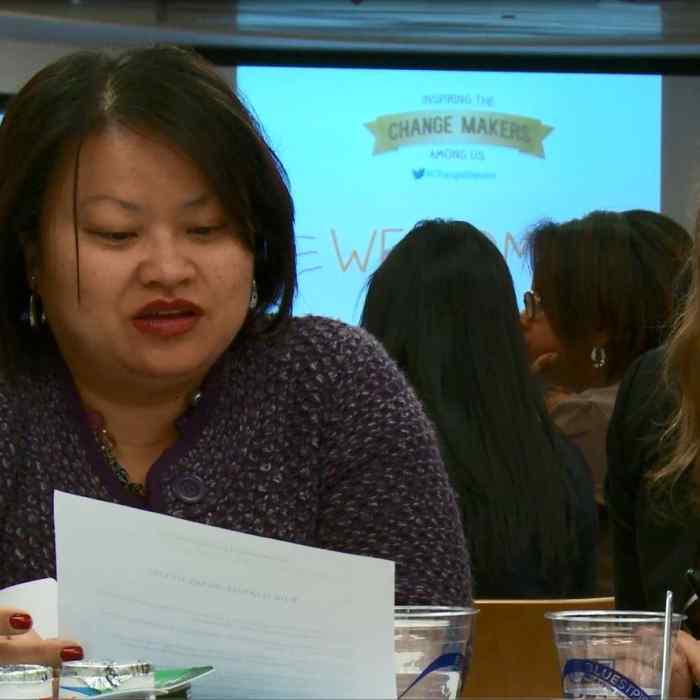 Two women looking at document and talking