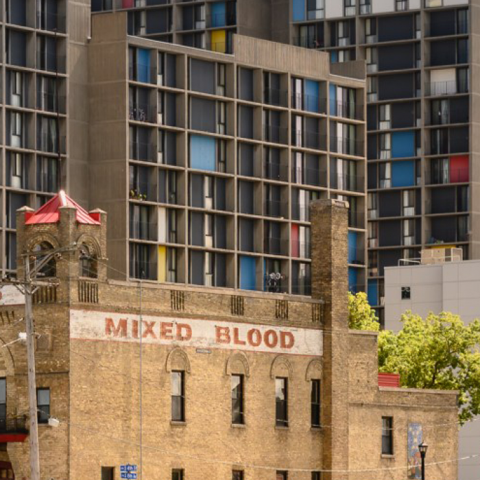 Mixed Blood Theater with Riverside Plaza rising behind it.