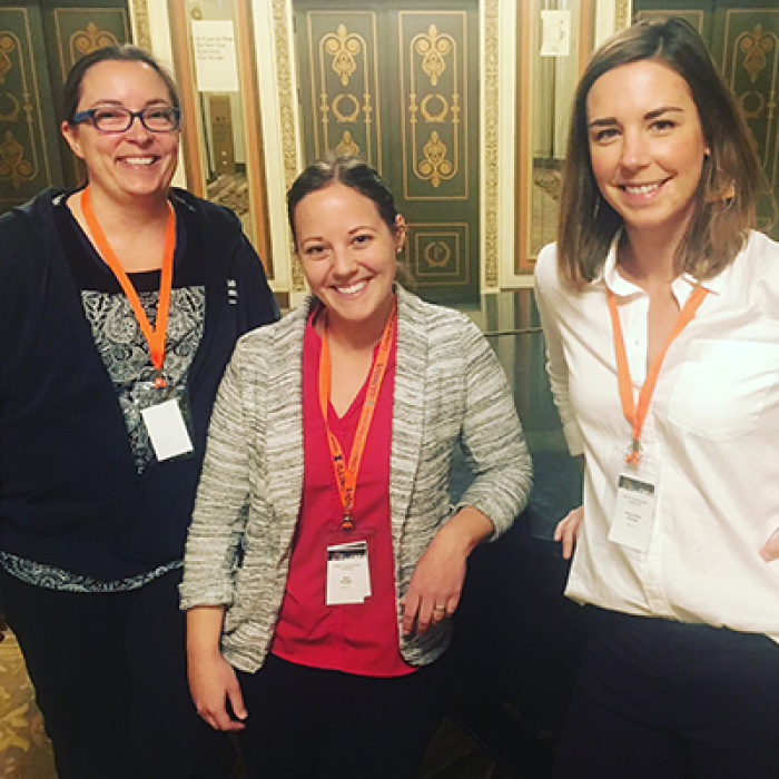 Nicole MartinRogers, Sera Kinoglu, and Anna Granias pose wearing conference badges.