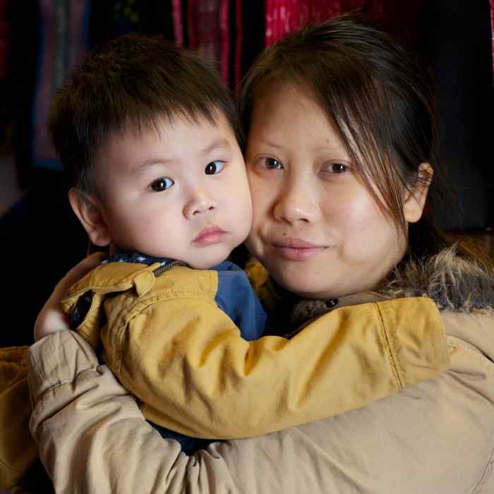 Mother holds her baby son in her arms