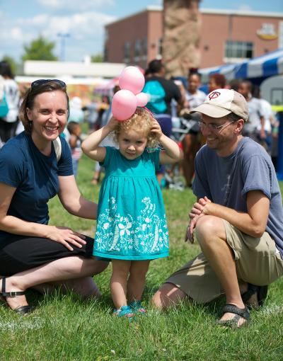 Mother and father with toddler holding a balloon