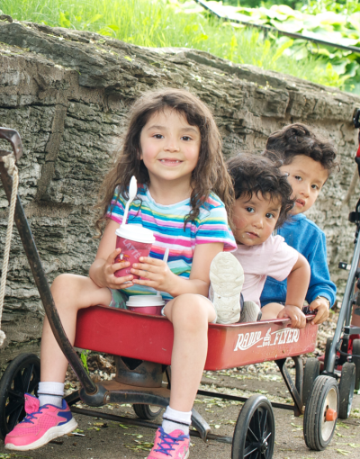 Children sitting on red wagon in Saint Paul, Minnesota