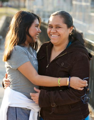 Mother daughter hugging on bridge