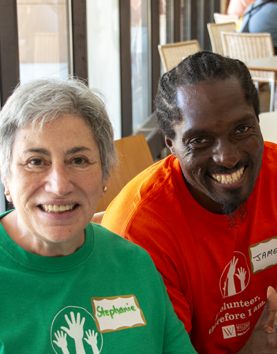 Wilder volunteers Stephanie and James sit at a registration table at a Wilder staff event