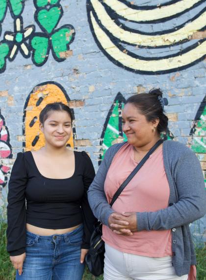 two women in front of a mural