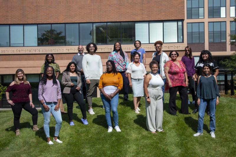 16 members of the Community Equity Program cohort posing outside Wilder Center