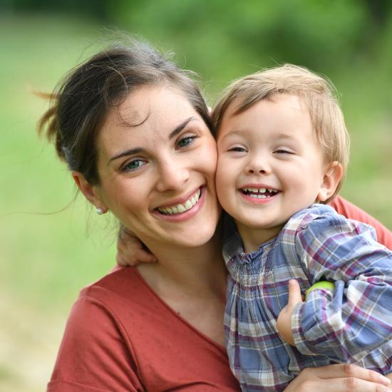 Mother holding child in her arms smiling