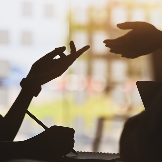 Silhouettes of two people talking.