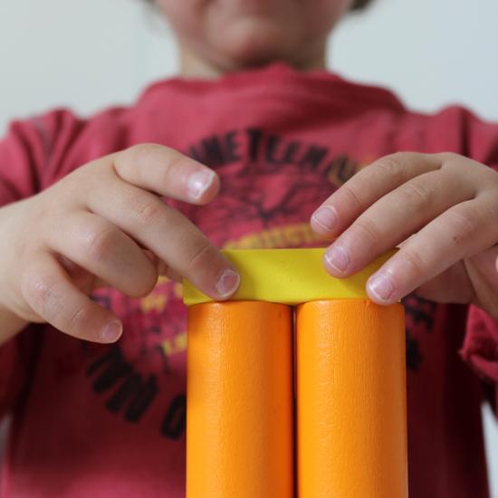 Child's hands playing with multi-colored blocks