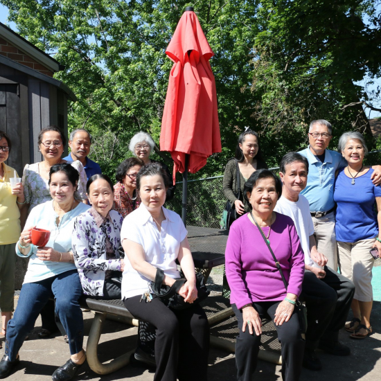 Members pose at a table near a donated shed outside the Wilder Center for Social Healing.