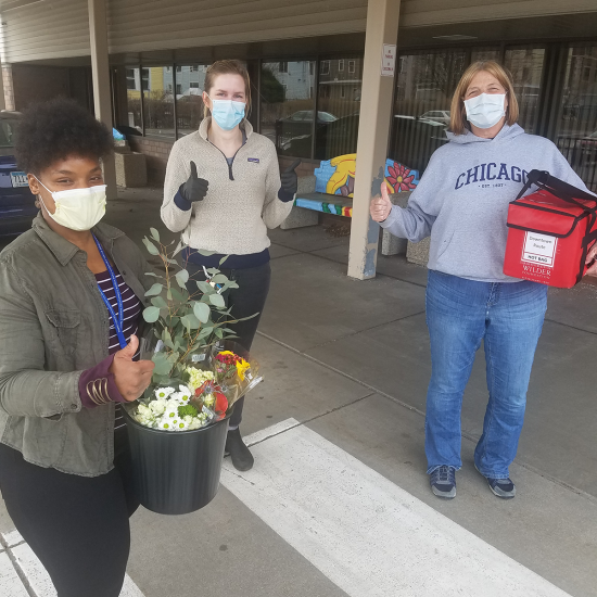 Meals on Wheels volunteers with masks and flowers at Wilder