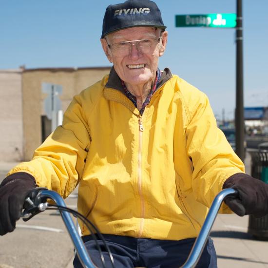 Man on a bike at an intersection smiling