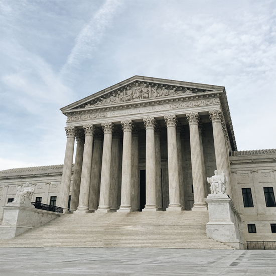 Wide angle photo of the U.S. Supreme Court building exterior's front facade, shot from a slightly lower angle