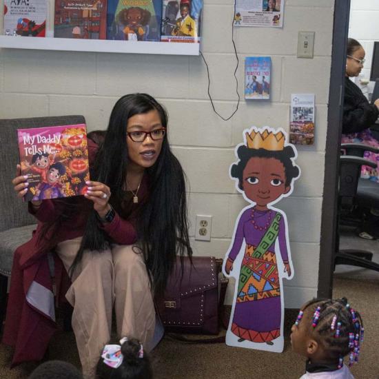 Author Thuba Nguyen reads to children at the Child Development Center