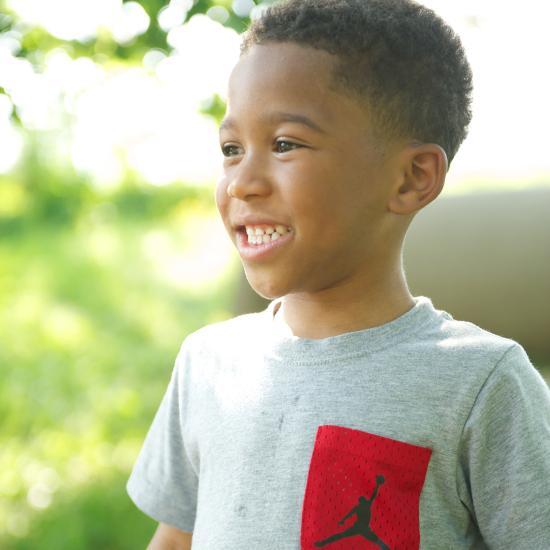 Young boy smiling outside