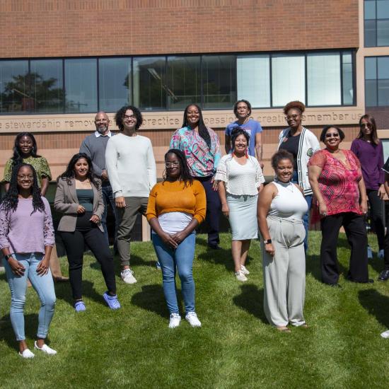 16 members of the Community Equity Program cohort posing outside Wilder Center