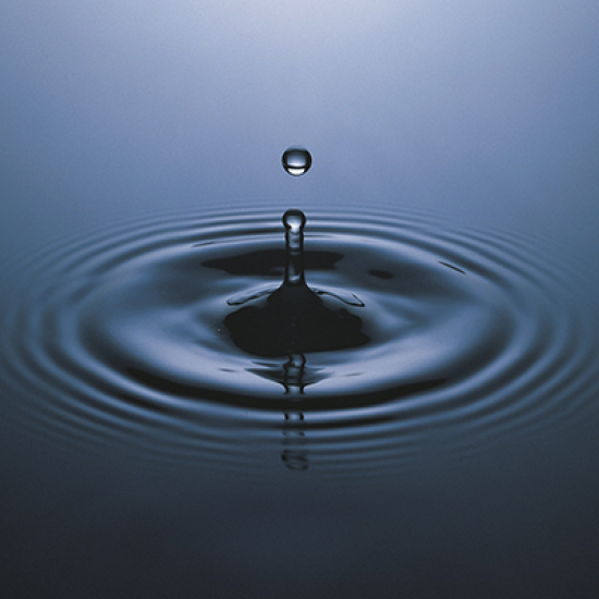 Close-up of a water droplet creating ripples.