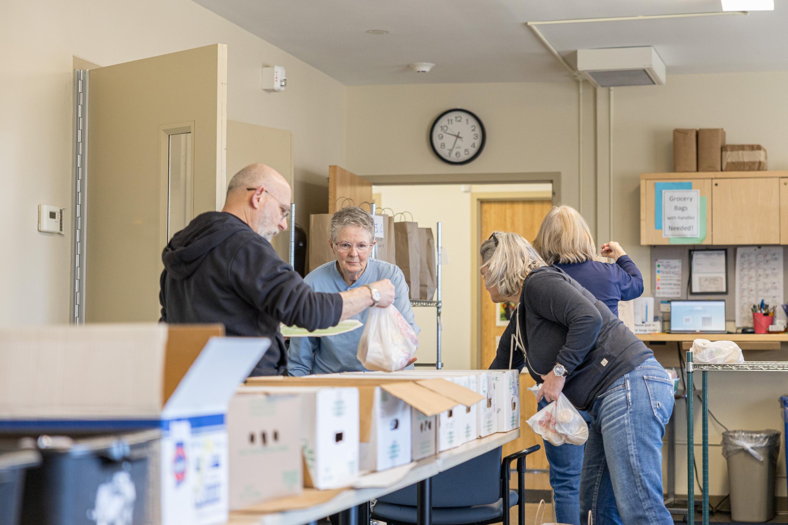 Meals on Wheels volunteers double checking meals.