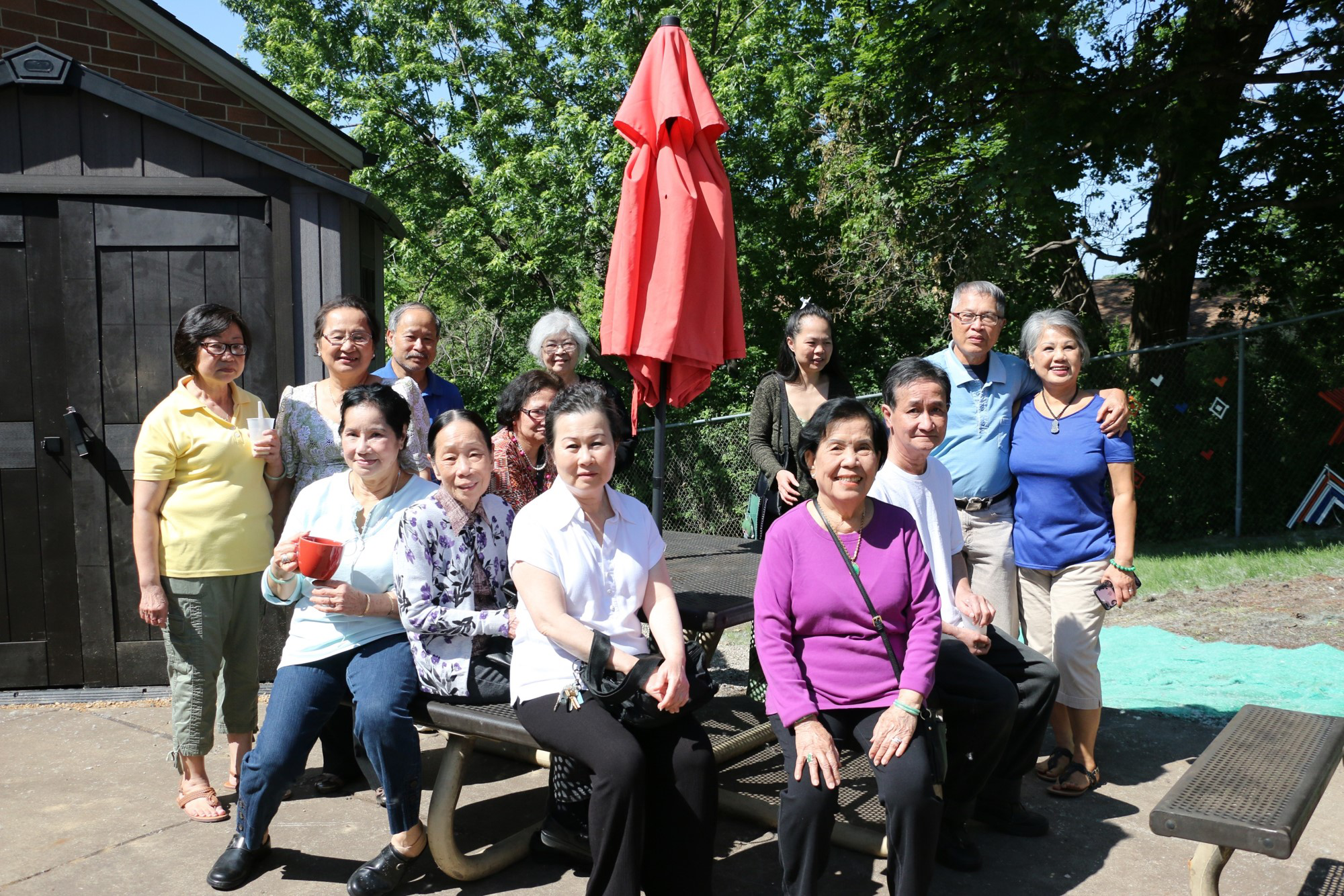 Members pose at a table near a donated shed outside the Wilder Center for Social Healing.