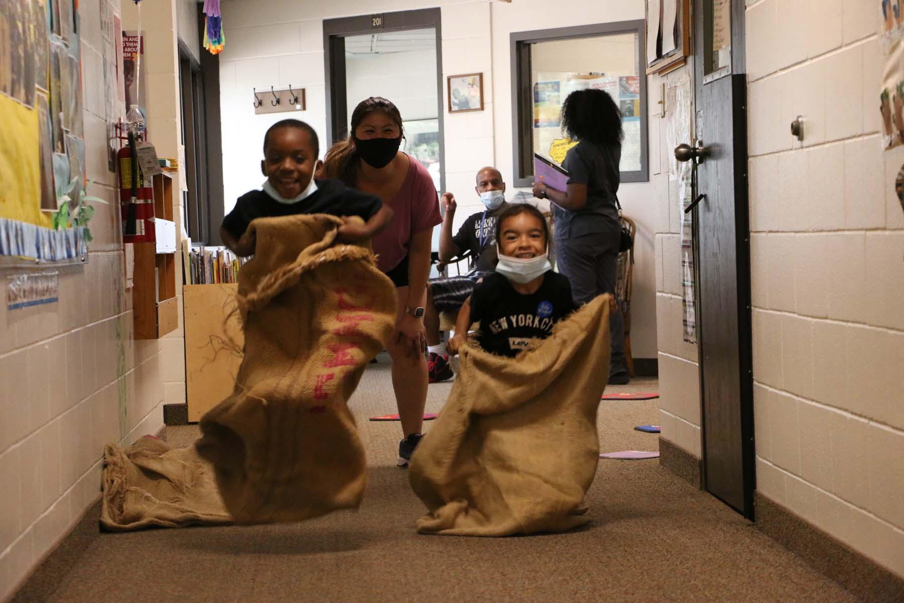 Kids doing sack races inside the Child Development Center during family fun night