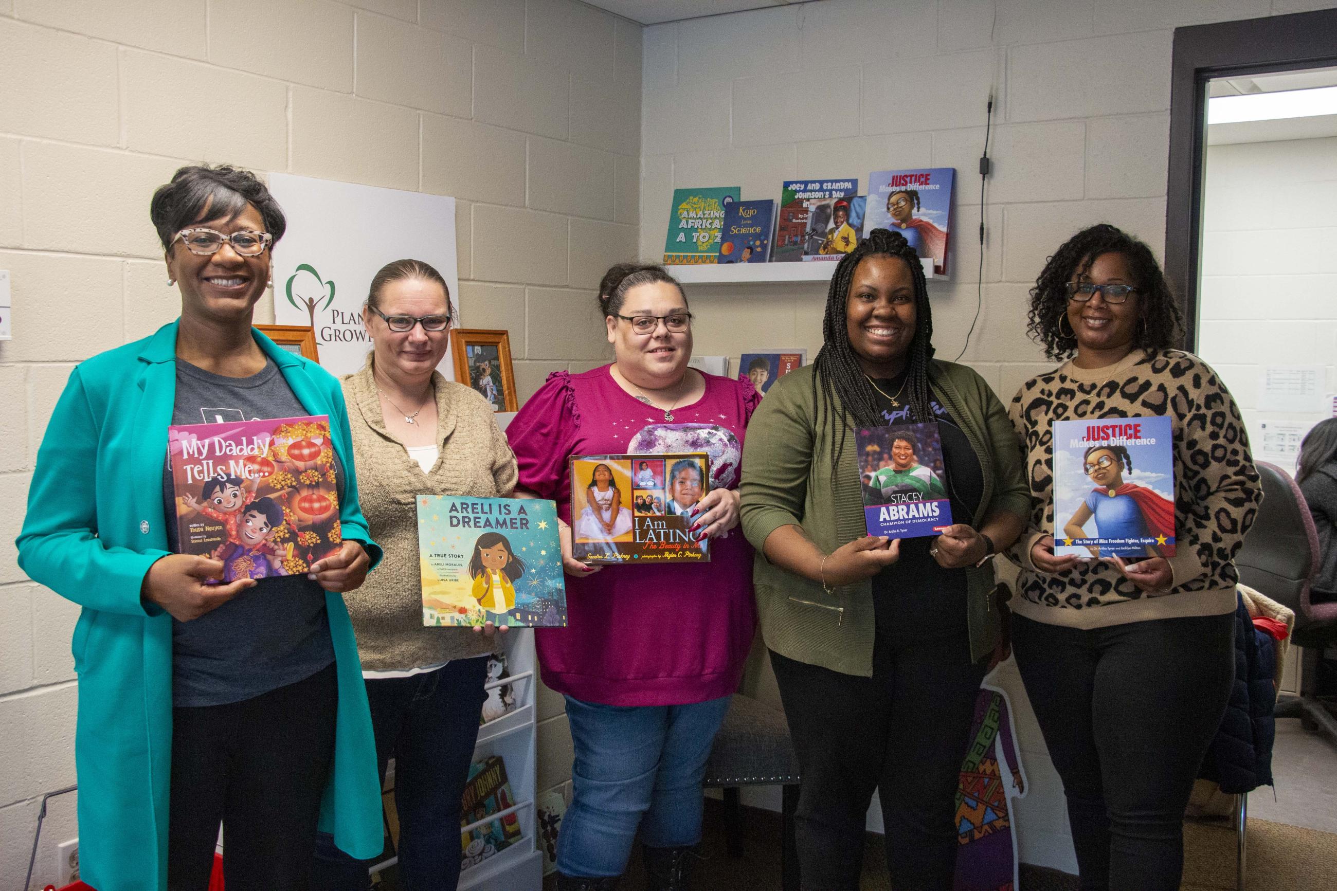 Five women posing together in the RAW Library at the Wilder Child Development Center