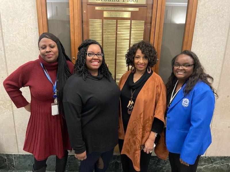 Four women standing together inside the Minnesota Capitol