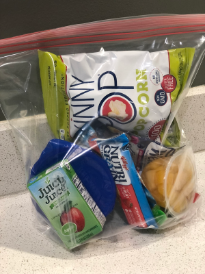one-gallon bag with popcorn, juice, cereal bar and other snacks