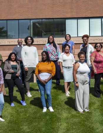 16 members of the Community Equity Program cohort posing outside Wilder Center