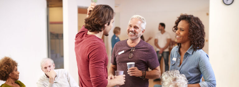 Group Of People Socializing After Meeting In Community Center