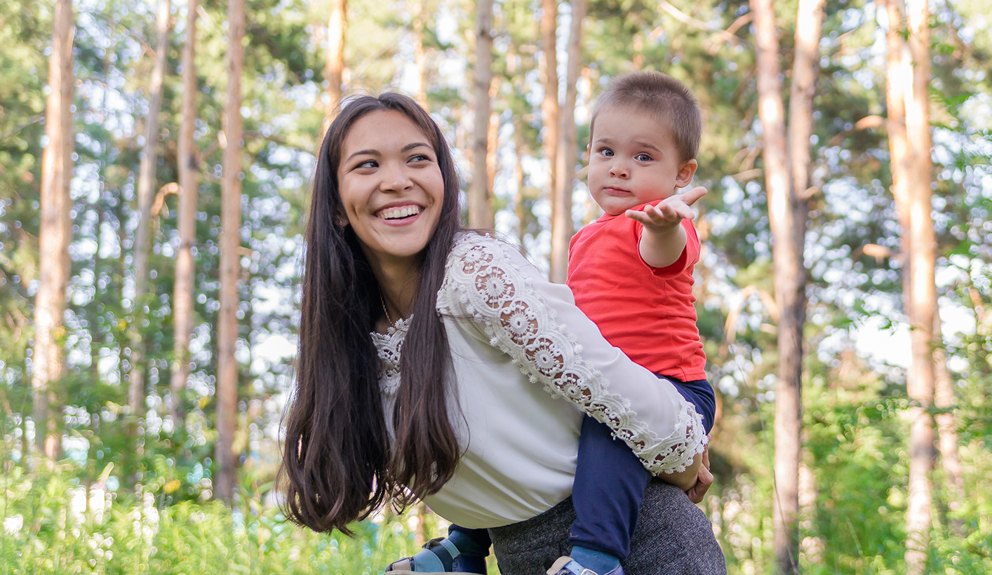 A happy young mother plays and has fun with her little son in t