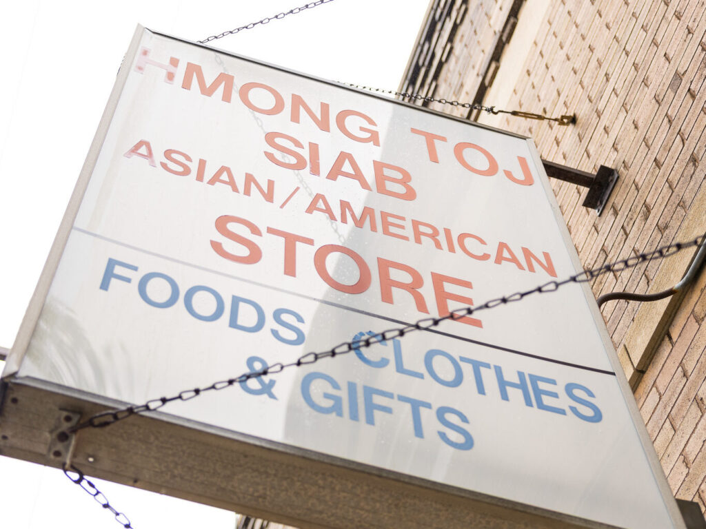 May’s family grocery store sign, reading: Hmong Toj Siab Asian/American Store – Food, Clothes & Gifts.