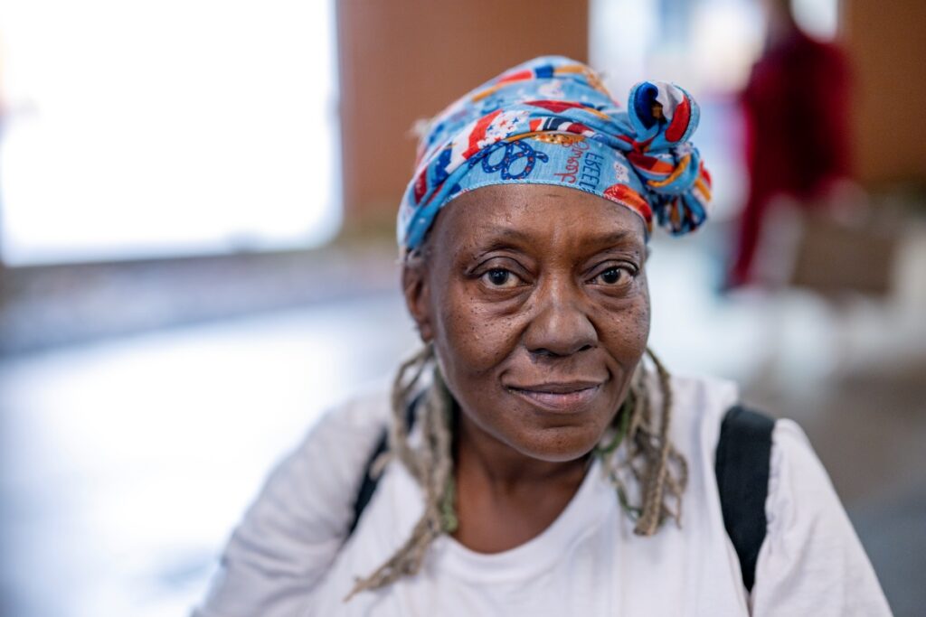 A woman in a colorful headscarf looking into the camera