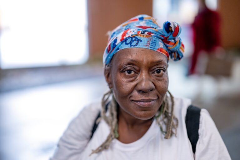 A woman in a colorful headscarf looking into the camera