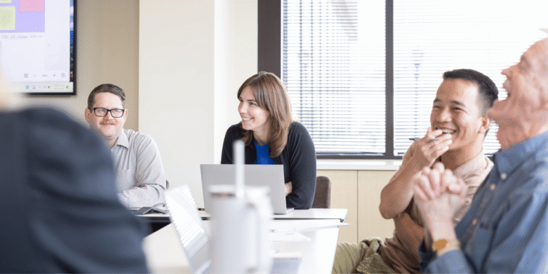 People smiling around computers
