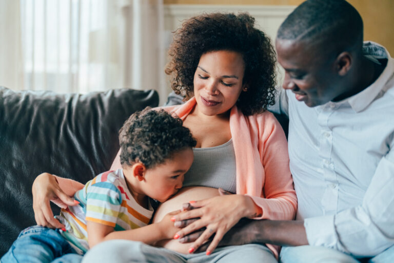 Pregnant woman with husband and son at home