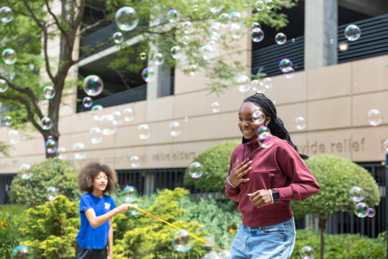 Two girls jumping rope with bubbles floating around them at Wilder