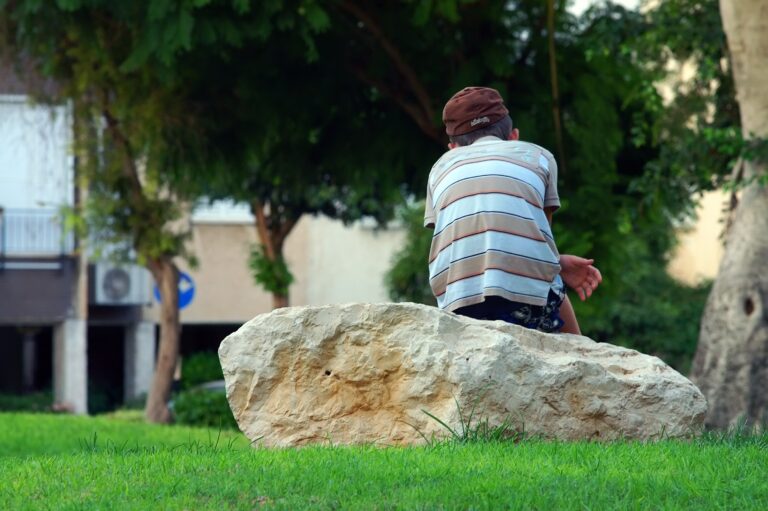 Young person sitting on a rock with back to the camera